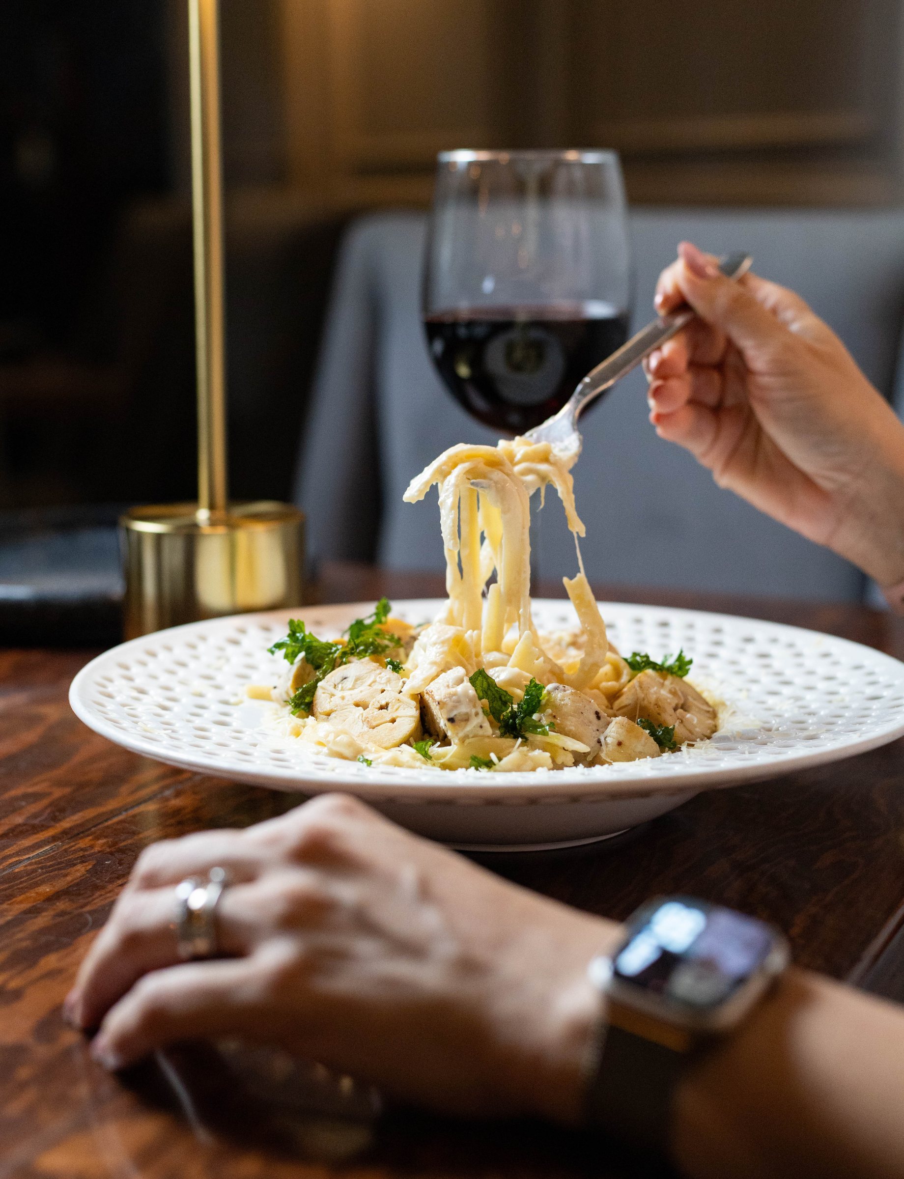 Pasta de Romaní servida en mesa, con copa de vino al fondo
